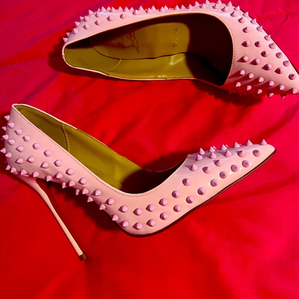 Beautiful pink spiked heels with a red bottom.